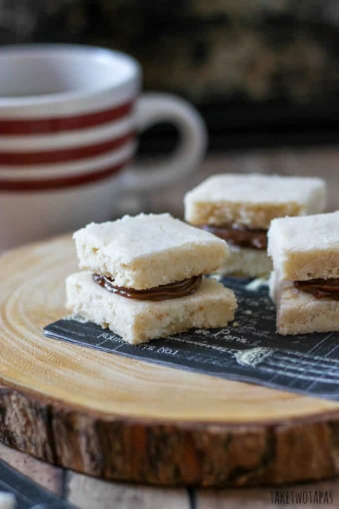 Soft buttery shortbread is elevated and made into a small sandwich cookie with the addition of chocolate caramel! This creamy and sweet chocolate caramel sauce is made int eh crock pot overnight and is the perfect addition to the shortbread cookie! Chocolate Caramel Shortbread Sandwich Cookie Recipe | Take Two Tapas