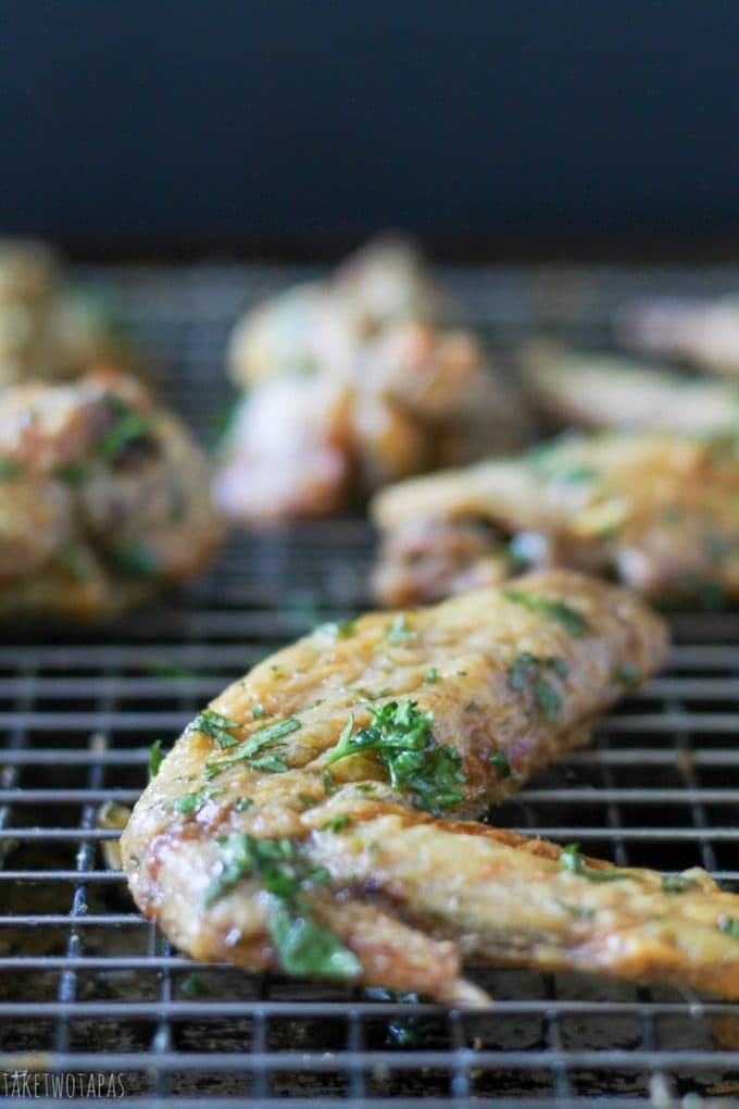 Looking for a chicken wing that is crispy, baked, but has a fresh taste? These green herb chicken wings are tender because they are marinated in vinegar and then tossed in a sauce of fresh parsley and cilantro! Crispy Green Herb Chicken Wings Recipe | Take Two Tapas | #GreenHerb #ChickenWings #Herbs