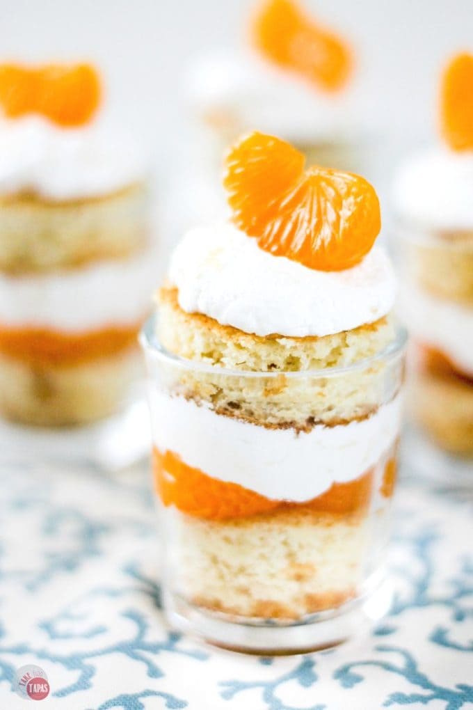 Fluffy cake, pineapple whip cream, and mandarin orange segments make a great Orange Sunrise Shooter dessert for Summer. | Take Two Tapas | #PigPickinCake #Orange #MandarinOranges #SunshineCake #PigLickinCake #CakeRecipe #PigPickinCakeRecipe
