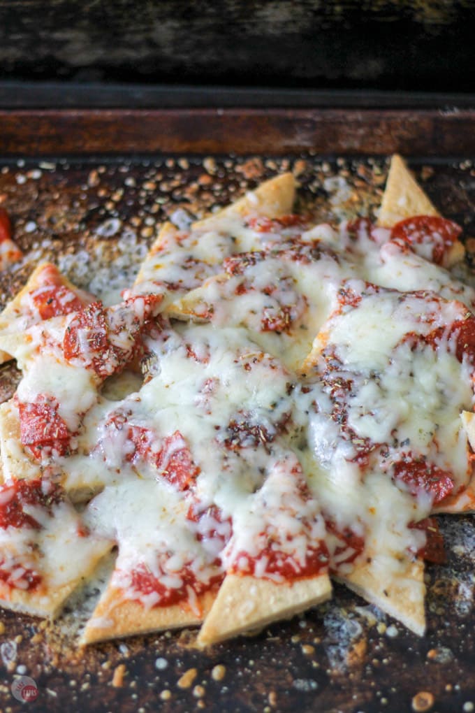 Your favorite pepperoni pizza is now nachos! Tangy pizza sauce drizzled on crispy pizza dough crust chips, topped with pepperoni and melted cheese. Pizza Nachos with Pizza Crust Chips Recipe | Take Two Tapas