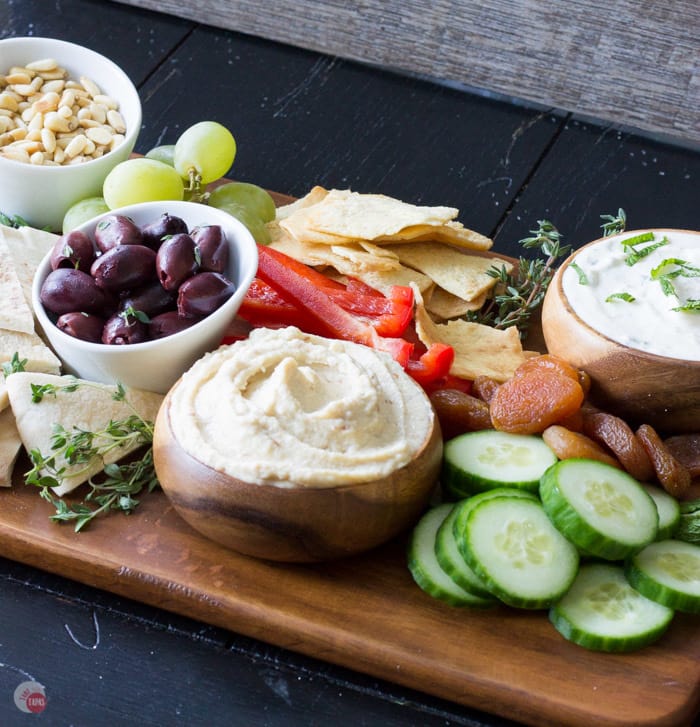 angle latéral de houmous dans un bol avec des poivrons tranchés et un bol d'olives