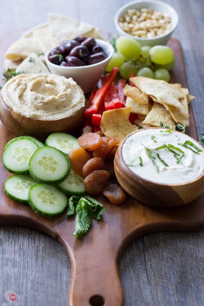 side view of sliced vegetables and bowls of hummus