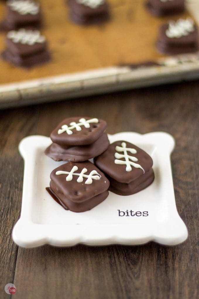 three football cookies on a white plate