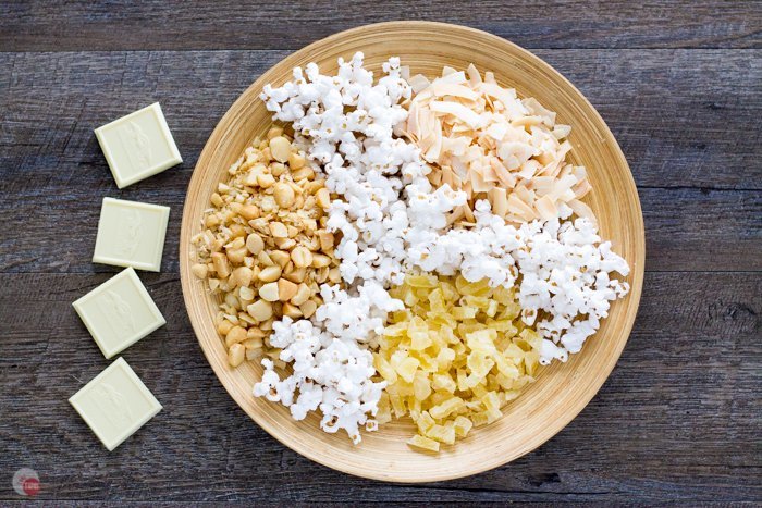 A tropical Hawaiian Popcorn snack mix of dried pineapple, toasted coconut chips, roasted macadamia nuts, drizzled in white chocolate. | Take Two Tapas | #Popcorn #Hawaiian #PopcornSnack #HealthySnacks #TrailMix #HealthyPopcornRecipe