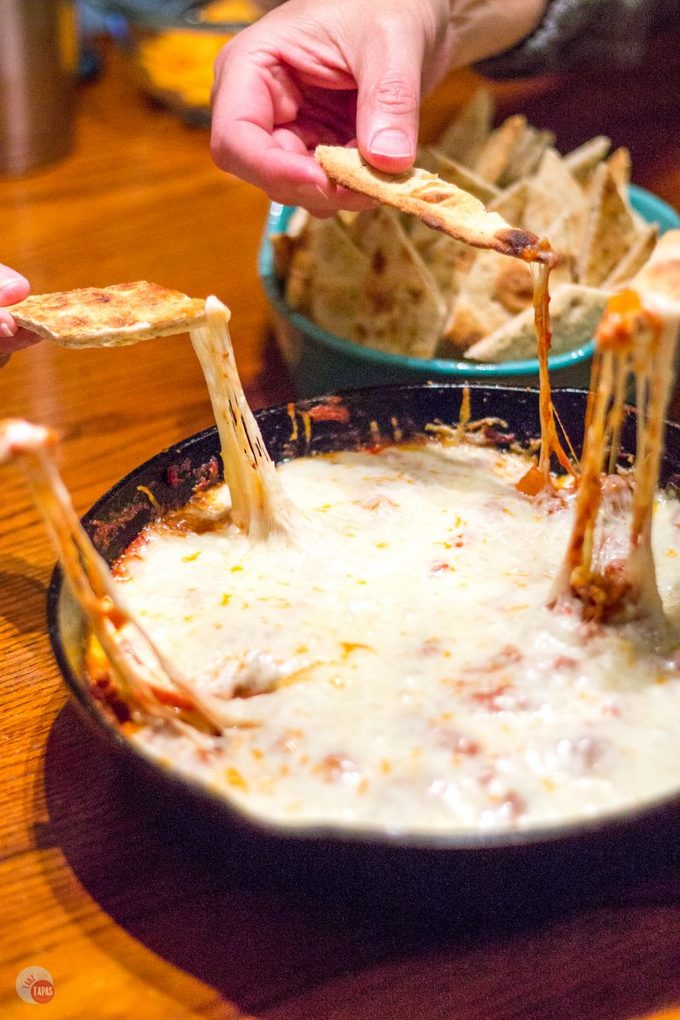 Slow simmered arrabbiata sauce mixed with sausage and veggies and topped with cheese makes the perfect dip to share with friends! Arrabbiata Skillet Sausage Dip with Pizza Chips Recipe | Take Two Tapas