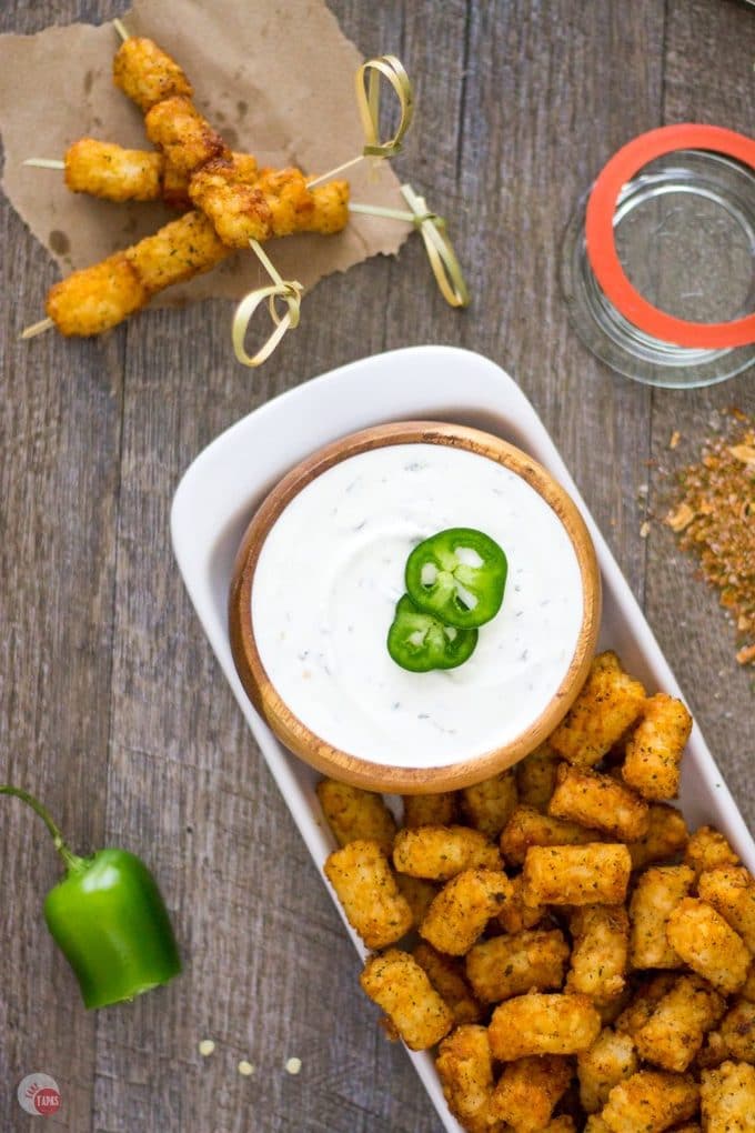 Warm and spicy steakhouse tater tots have the right amount of kick with my homemade steak seasoning. Take them for a cool dip in jalapeno ranch for an awesome snack! Perfect for the big game or any tater tot craving! Steakhouse Tater Tots with Jalapeno Ranch Dip | Take Two Tapas