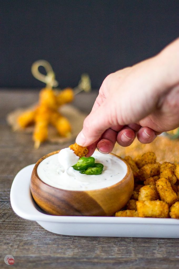 Warm and spicy steakhouse tater tots have the right amount of kick with my homemade steak seasoning. Take them for a cool dip in jalapeno ranch for an awesome snack! Perfect for the big game or any tater tot craving! Steakhouse Tater Tots with Jalapeno Ranch Dip | Take Two Tapas