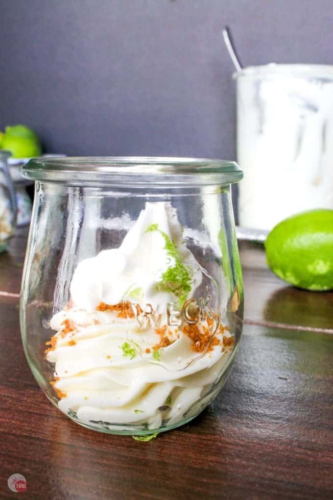 Key lime cheesecake with a hint of coconut brings me back to the tropics! Having the crust on top makes me feel like a rebel and want to eat dessert first! Key Lime Coconut Cheesecake Jars Recipe | Take Two Tapas | #KeyLime #Cheesecake #Coconut #nobake #desserts