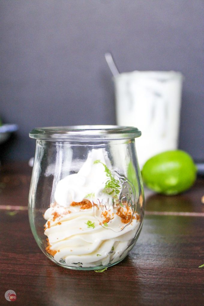 An easy, no bake, tropical dessert. Key Lime Coconut Cheesecake Jars Recipe | Take Two Tapas | #KeyLime #Cheesecake #Coconut #nobake #desserts