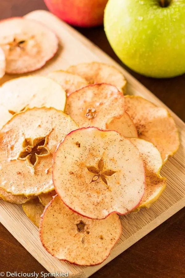 Baked apple chips on a wooden serving board