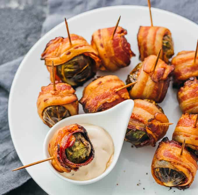 bacon wrapped brussels sprouts on a white plate