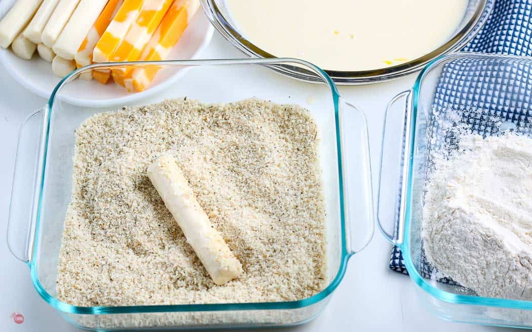 cheese stick in a bowl of panko crumbs