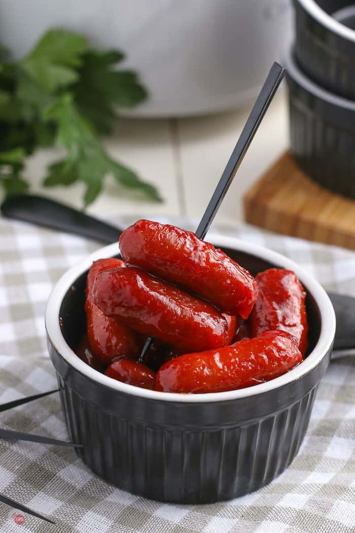 cocktail weenies in a black bowl with a toothpick