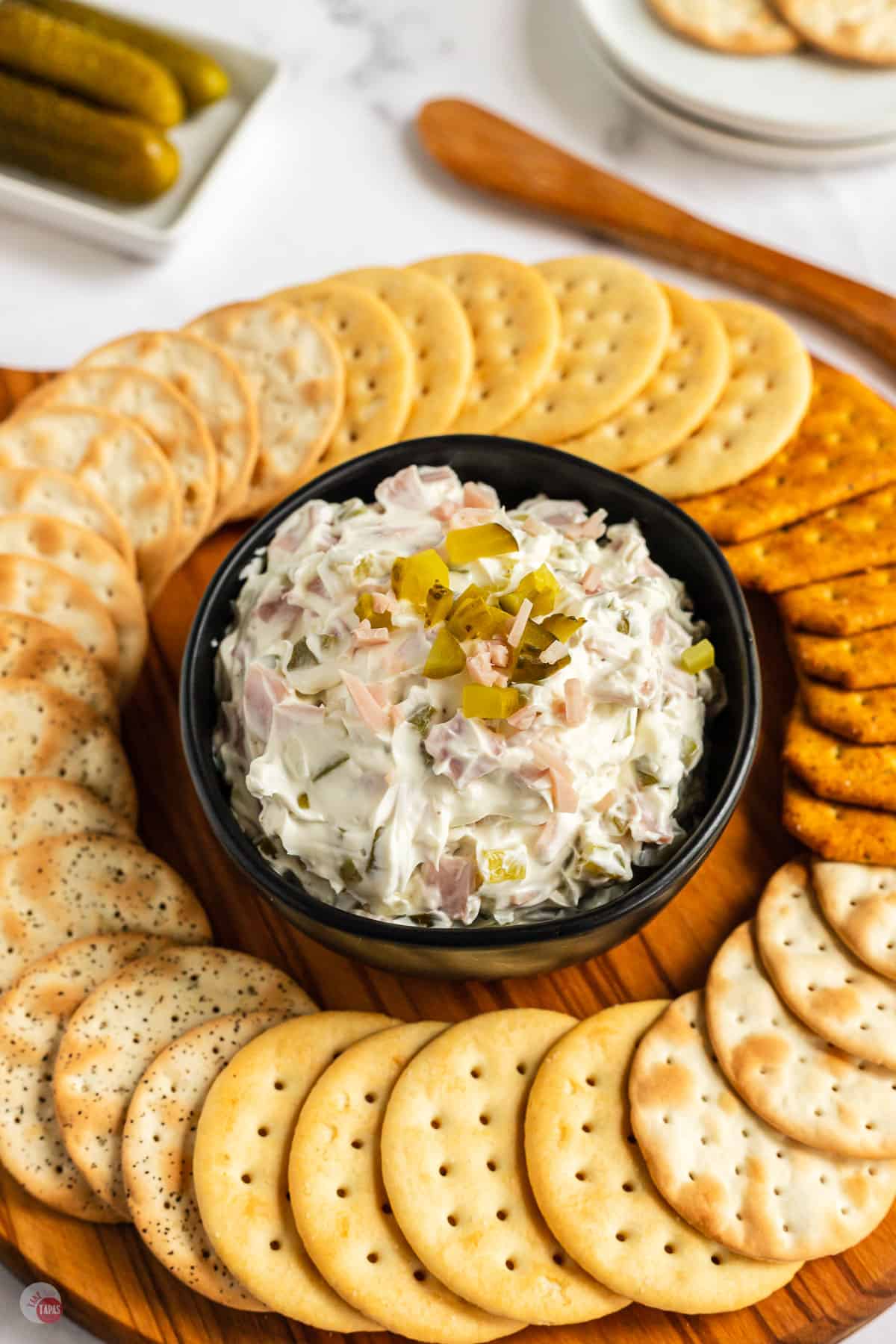 bowl of pickle dip with crackers around it