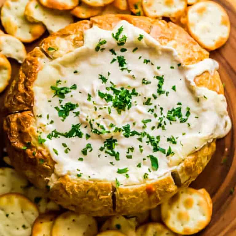 Close up of someone dipping their bread into the creamy Beer Cheese Dip Bowl