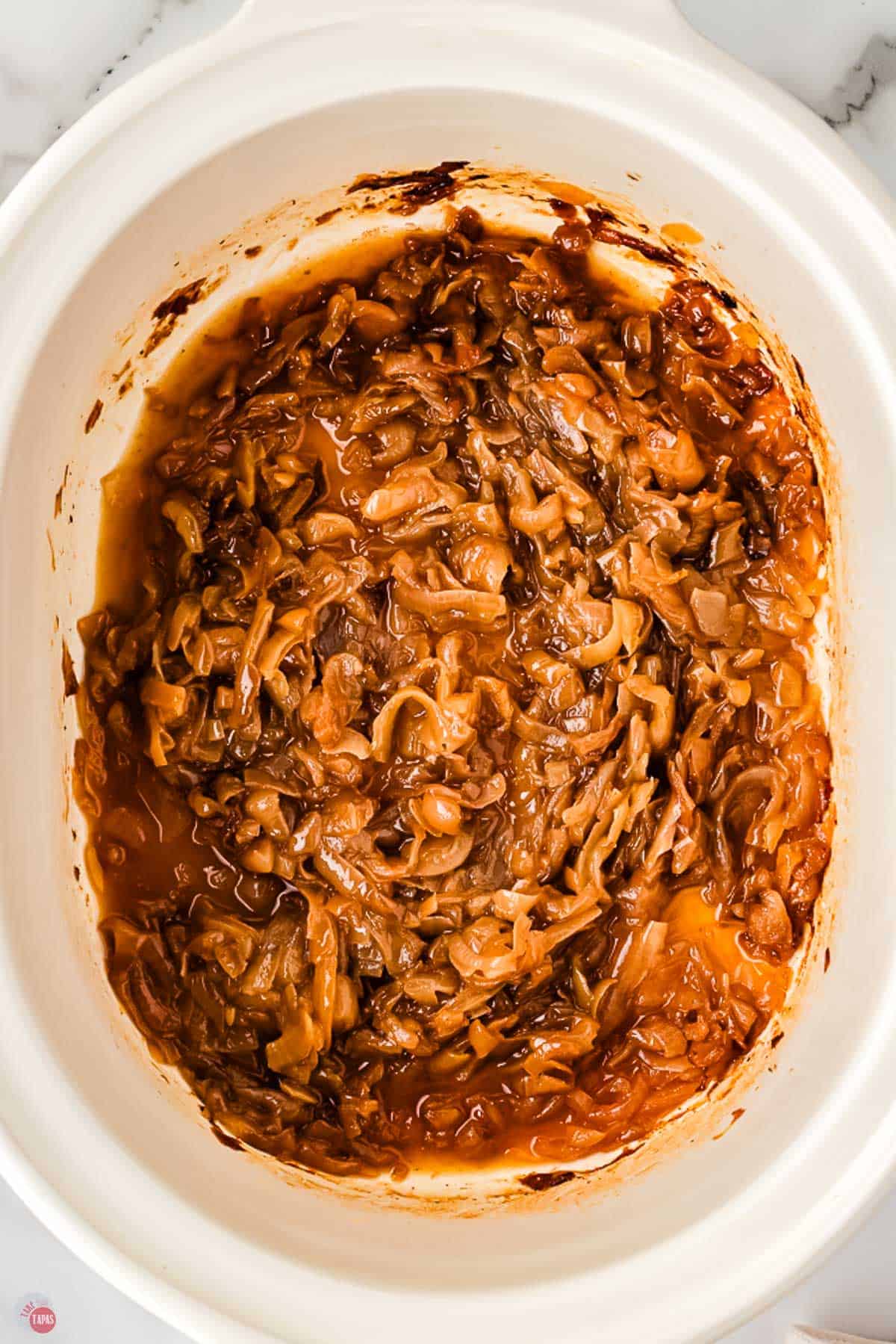 slow cooker caramelized onions in a white pot