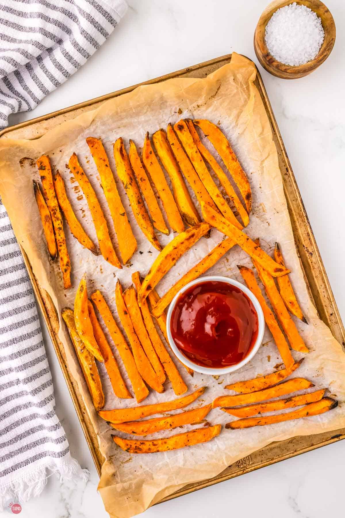 sweet potato fries on a baking sheet with ketchup