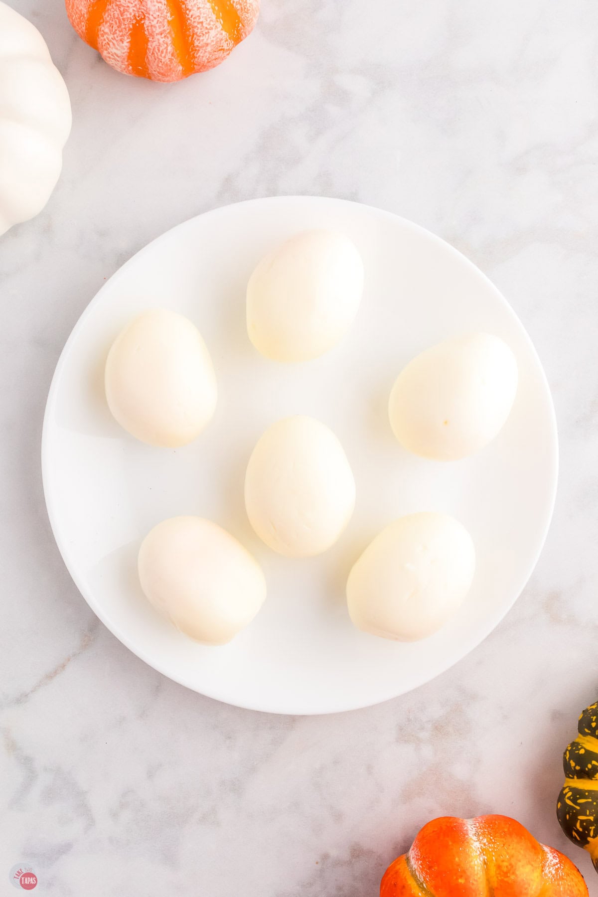 peeled hard-boiled eggs on a white plate