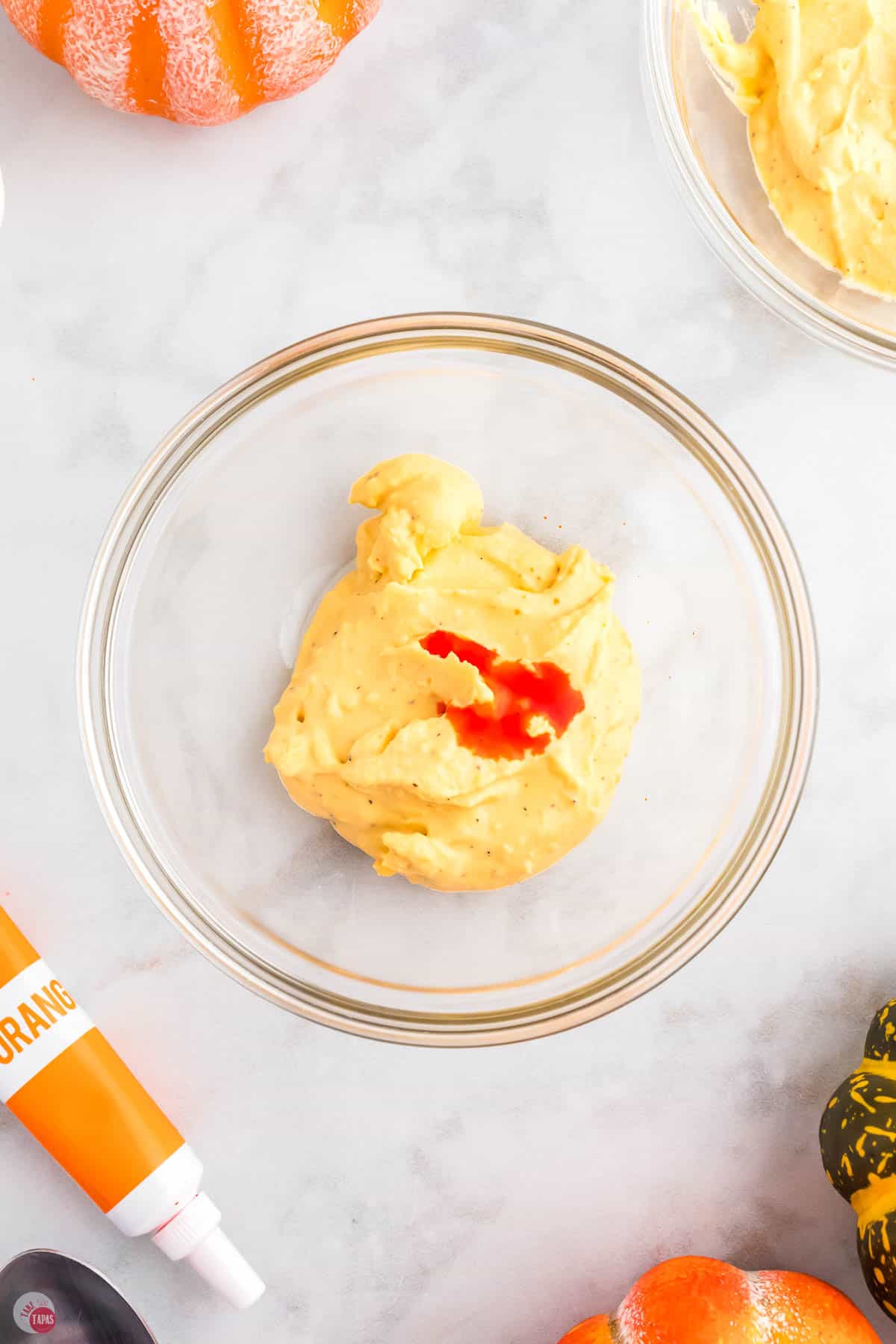 orange food coloring on deviled egg mixture in a bowl