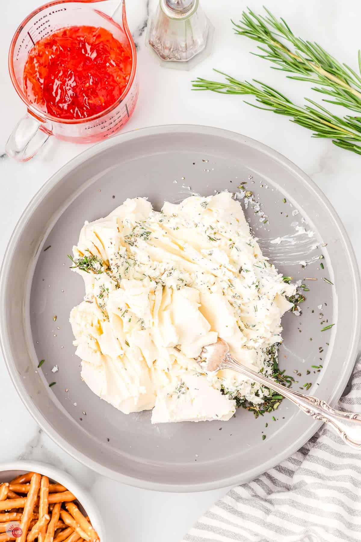 cream cheese being mashed with a fork