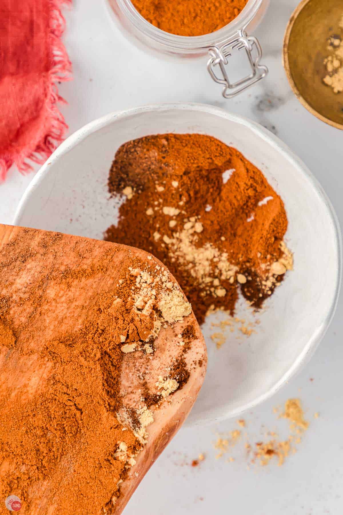 spices being poured into a white bowl