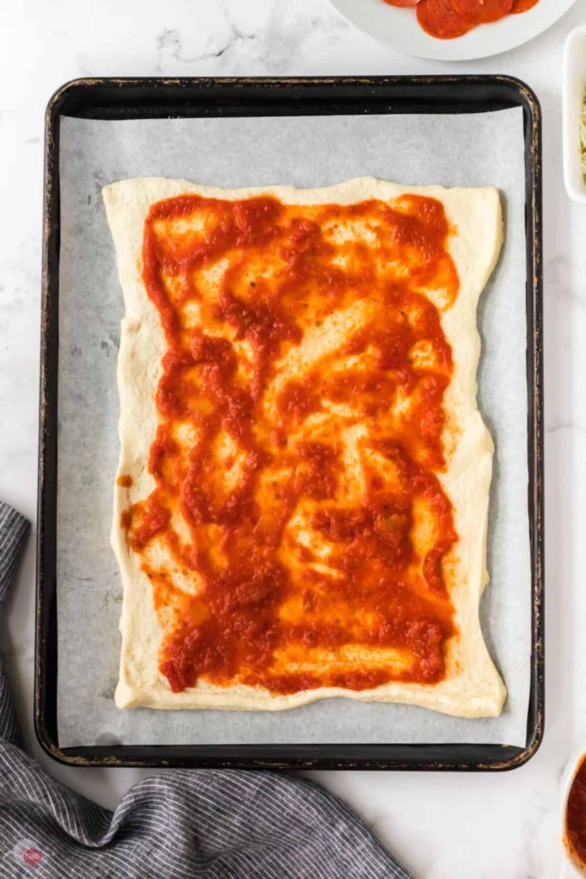 pizza dough with sauce on top