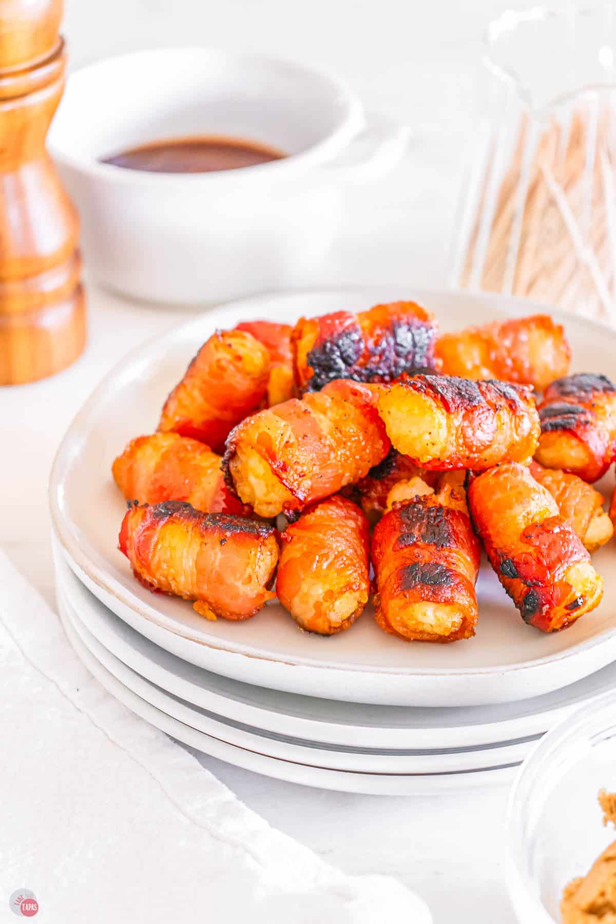 stack of plates with tater tots and bacon in a pile on them