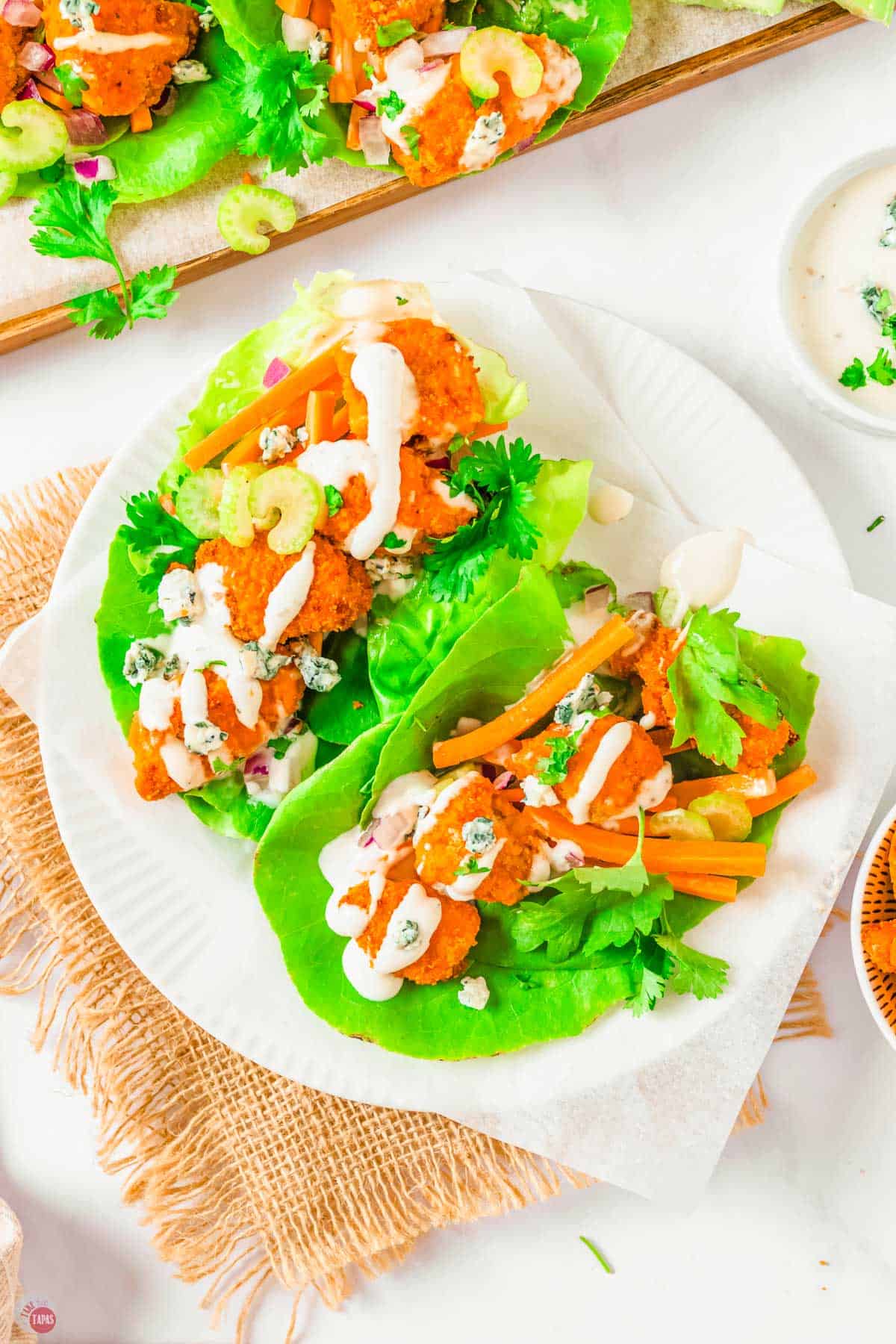 two buffalo chicken lettuce wraps on a white plate