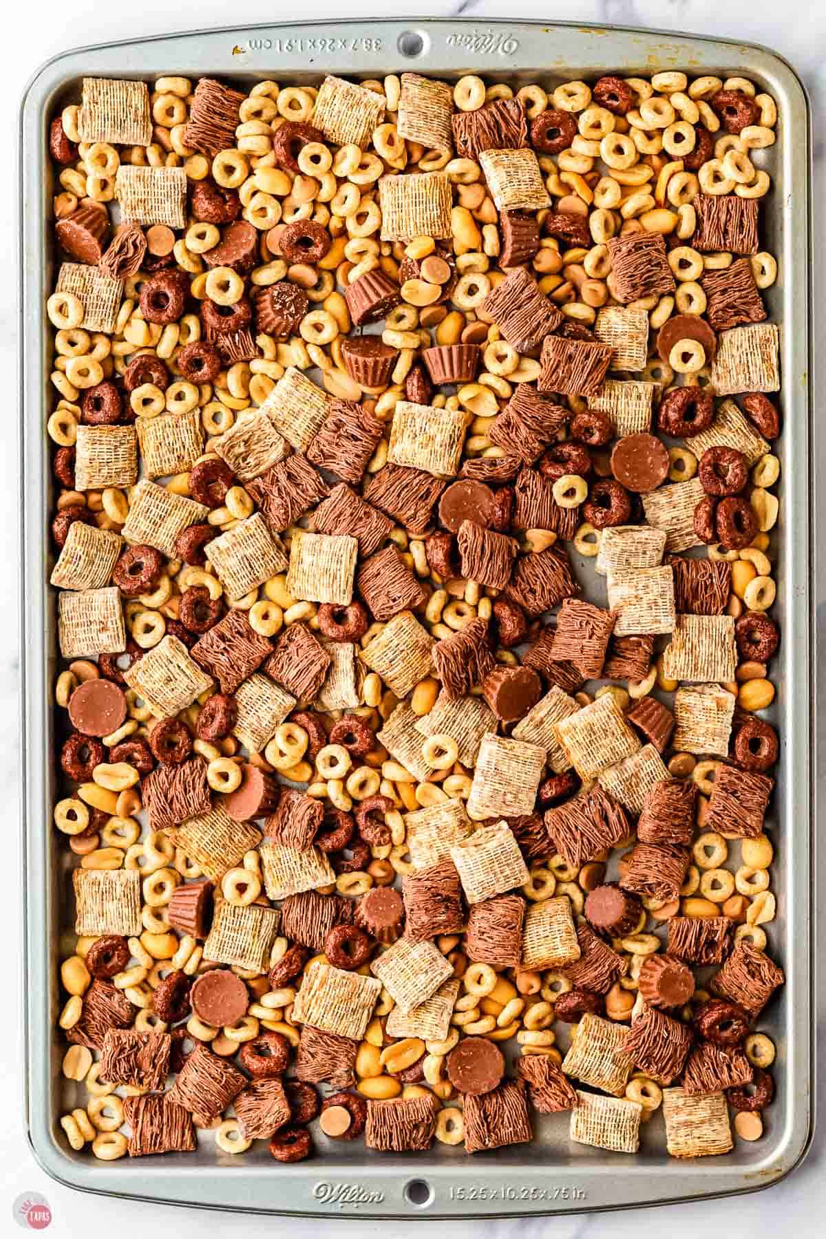 snack mix spread out on a baking sheet