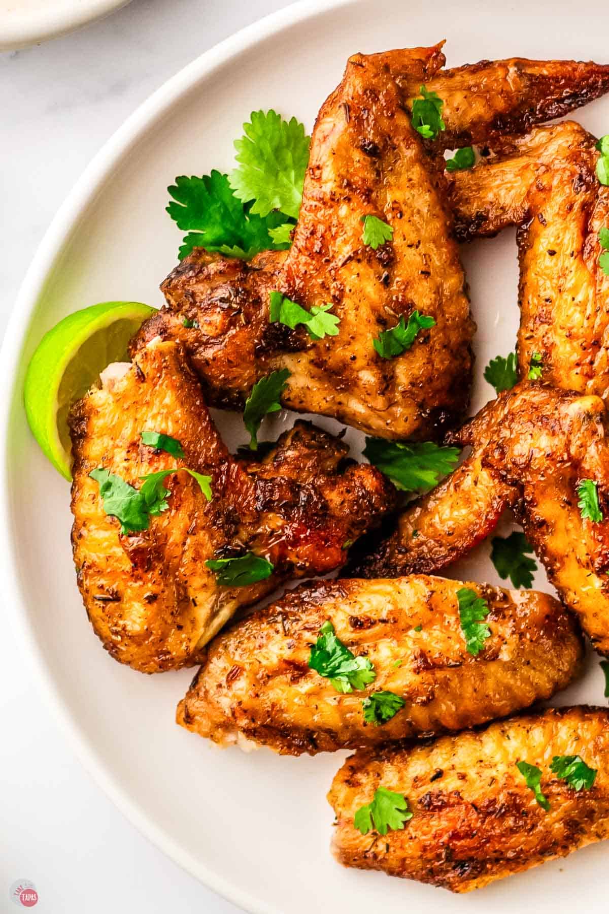 plate of chicken wings with chopped parsley on top