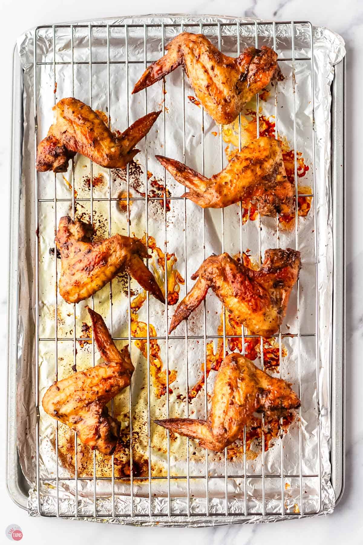 baking sheet with baked jerk chicken wings on it