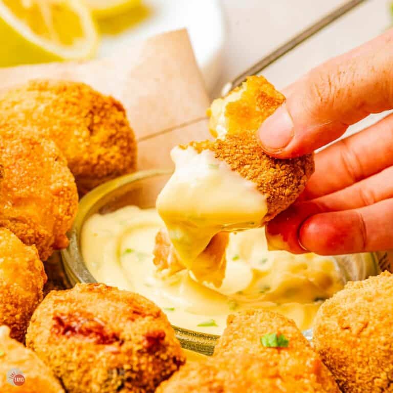 mushroom croquettes being dipped into a sauce