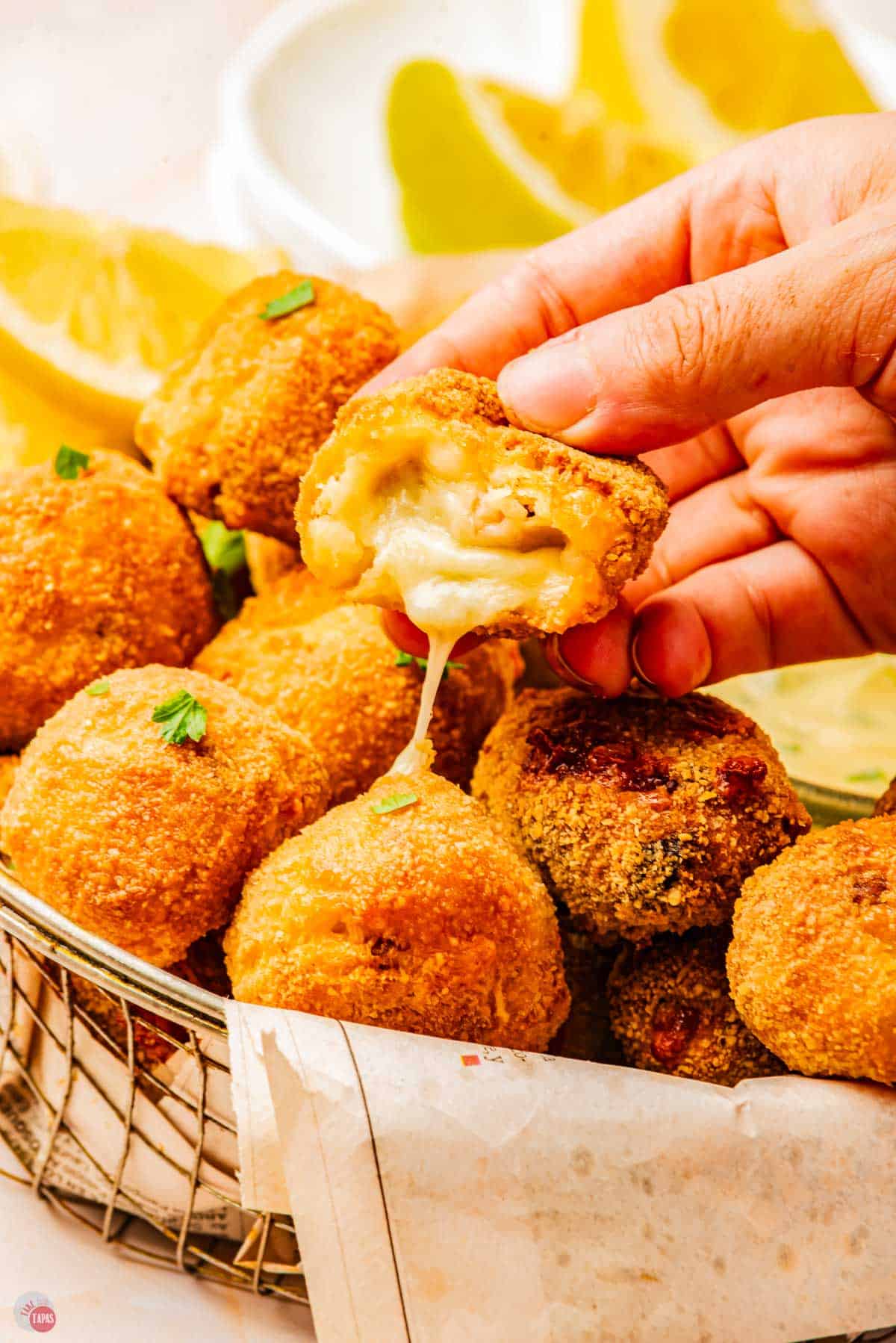 hand holding a mushroom potato croquette with a bite taken out of it