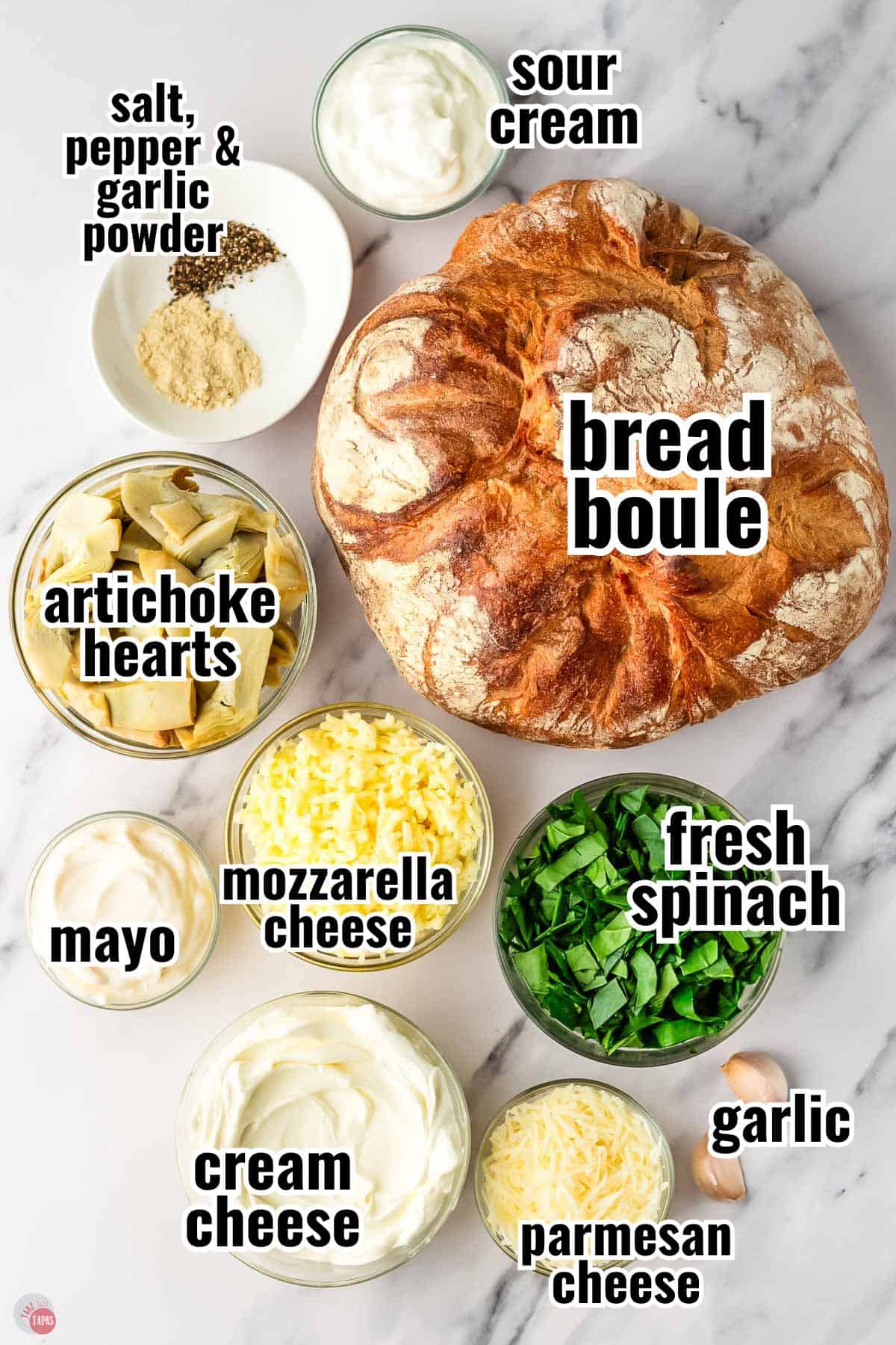 labeled ingredients for a baked spinach and artichoke dip served in a bread bowl