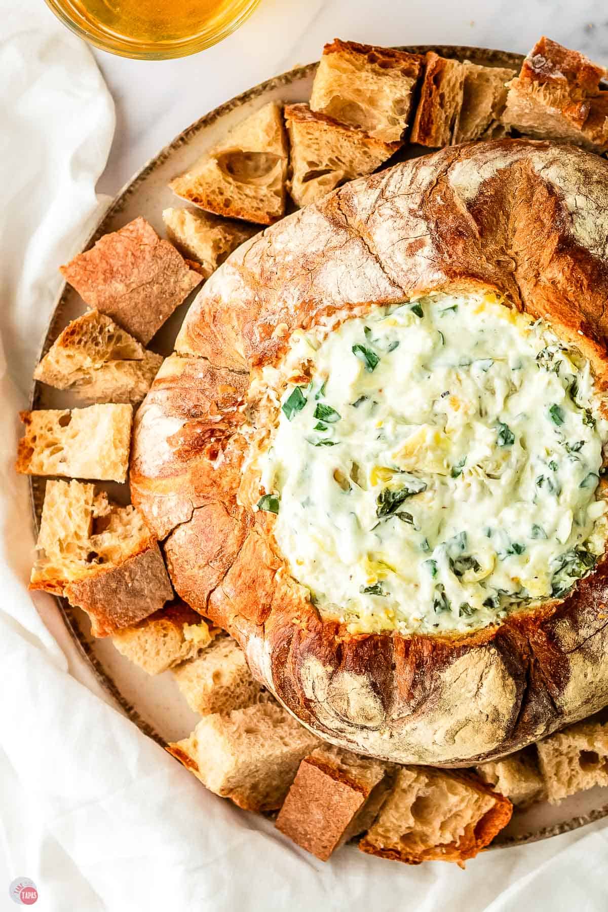 spinach dip with artichokes in a bowl made of bread