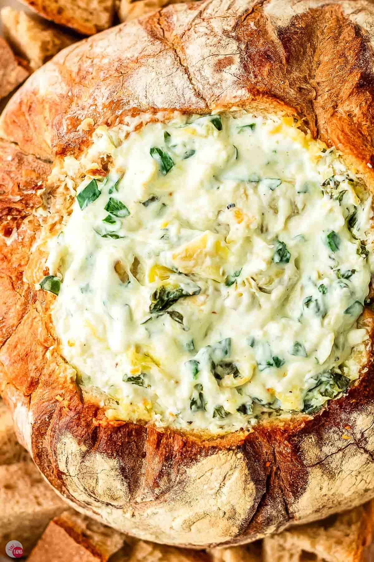 baked spinach artichoke dip in a sourdough bread loaf